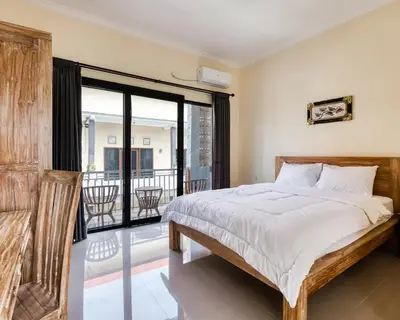 a bedroom with a large bed and a balcony at Dhita Kubu in Kerobokan