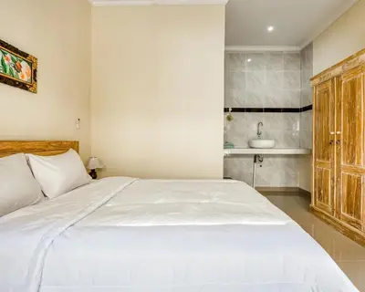 a bedroom with a large white bed and a sink at Dhita Kubu in Kerobokan
