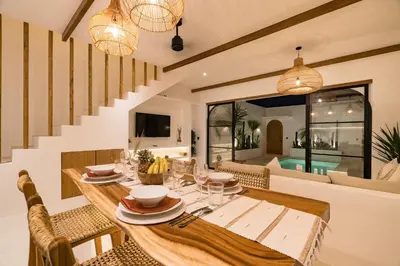 a dining room with a wooden table and chairs at Villa Casa Gaia 1 by BaliSuperHost in Umalas