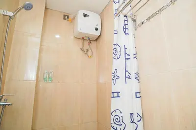 a bathroom with a shower with a shower curtain at Fun Living Guest House in Seminyak