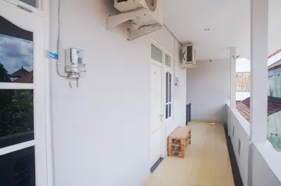 an empty hallway of a building with a window at Fun Living Guest House in Seminyak