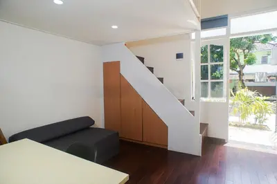 a living room with a staircase and a table at Fun Living Guest House in Seminyak
