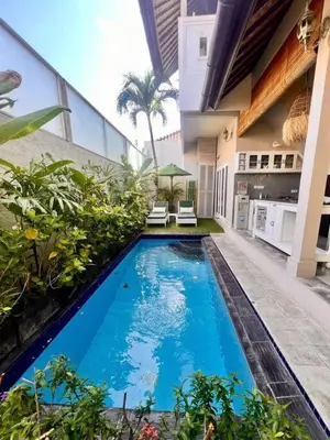 a swimming pool in the middle of a building at Frangipani Villa Seminyak - 2BR Pool Walk to Beach in Seminyak