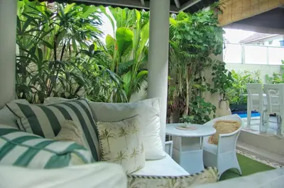 a porch with a couch and a table and plants at Frangipani Villa Seminyak - 2BR Pool Walk to Beach in Seminyak