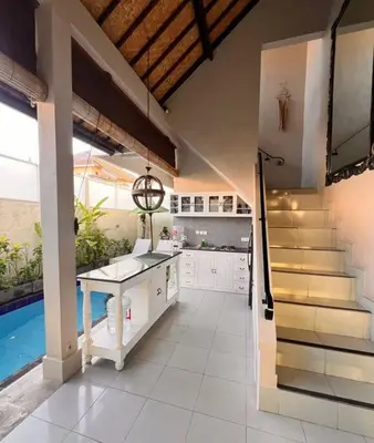 a kitchen with a staircase and a pool in a house at Frangipani Villa Seminyak - 2BR Pool Walk to Beach in Seminyak