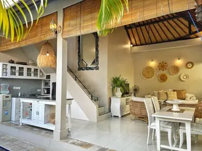 a kitchen and living room with a table and a staircase at Frangipani Villa Seminyak - 2BR Pool Walk to Beach in Seminyak