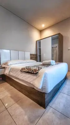 a large bed with a wooden frame in a room at Villa by BALIem in Jimbaran