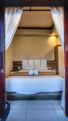 a large white bed with two towels on it at Villa by BALIem in Jimbaran