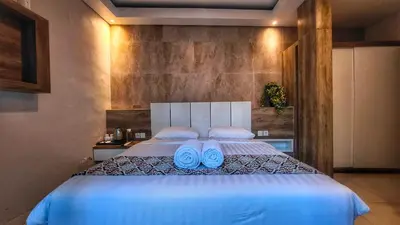 a bedroom with a bed with blue slippers on it at Villa by BALIem in Jimbaran