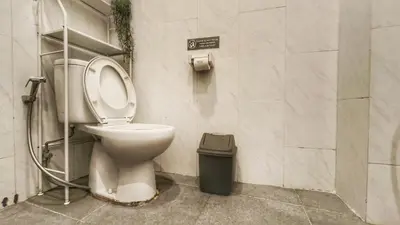a bathroom with a toilet and a trash can at Villa by BALIem in Jimbaran