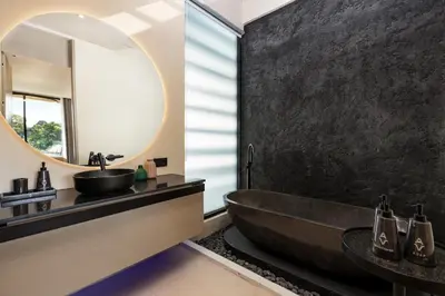a black bathroom with a tub and a mirror at Alex Villas Complex N5 in Canggu