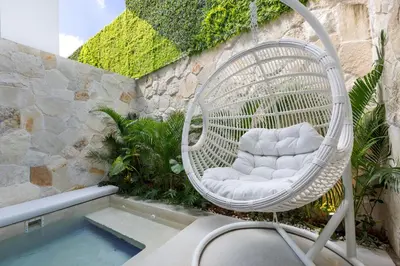a white wicker chair sitting next to a pool at Alex Villas Complex N5 in Canggu