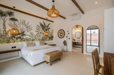 a bedroom with a bed and a table and chairs at Villa Casa Gaia 5 by BaliSuperHost in Kerobokan