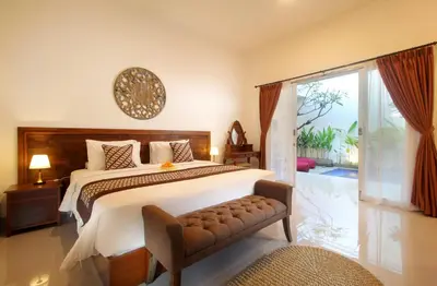 a bedroom with a large bed and a sliding glass door at Bougainvillea Villa Seminyak by Parigata in Seminyak