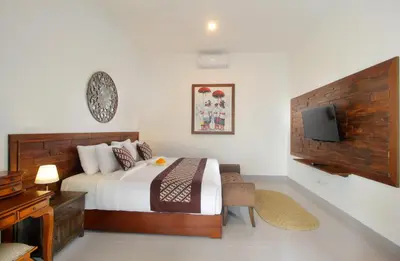 a bedroom with a bed and a tv on a wall at Bougainvillea Villa Seminyak by Parigata in Seminyak