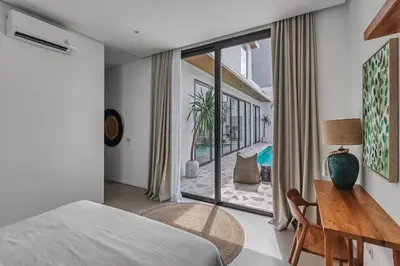 a bedroom with a bed and a desk and a window at New Magnificent 3BR 5min to Finns & Berawa Beach Villa Alemar in Canggu