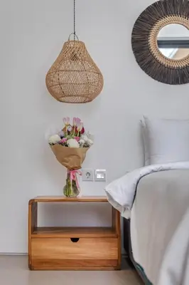 a table with a vase of flowers on a bed at New Magnificent 3BR 5min to Finns & Berawa Beach Villa Alemar in Canggu