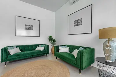 a living room with two green couches and a table at New Magnificent 3BR 5min to Finns & Berawa Beach Villa Alemar in Canggu