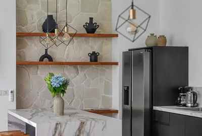 a kitchen with a table with a vase of flowers on it at New Magnificent 3BR 5min to Finns & Berawa Beach Villa Alemar in Canggu