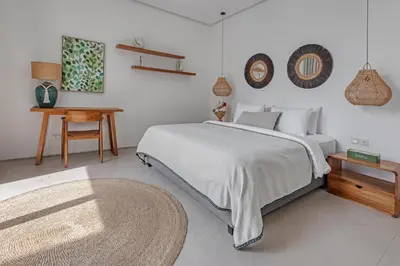 a bedroom with a bed and a table and a rug at New Magnificent 3BR 5min to Finns & Berawa Beach Villa Alemar in Canggu