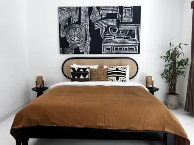 a bedroom with a large bed with black and white pillows at Villa Aliran - Modern Comfort in tranquil Umalas in Canggu