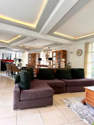a living room with a couch and a dining room at Greenhouse Villa in Kerobokan