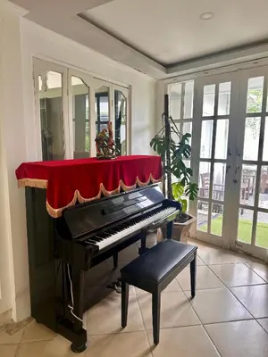 a piano in a room with a red blanket on it at Greenhouse Villa in Kerobokan
