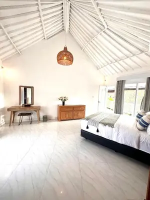 a bedroom with a bed and a desk in it at Greenhouse Villa in Kerobokan