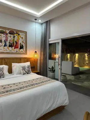 a bedroom with a large white bed in a room at Tirta Mumbul Villa in Badung