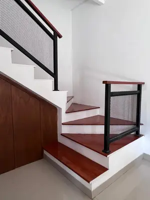 a staircase with white and brown wood and a black rail at Louise villa in Jimbaran