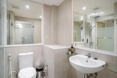 a bathroom with a toilet and a sink and a mirror at Bali Bustle Sunset Coliving and Coworking Space in Legian
