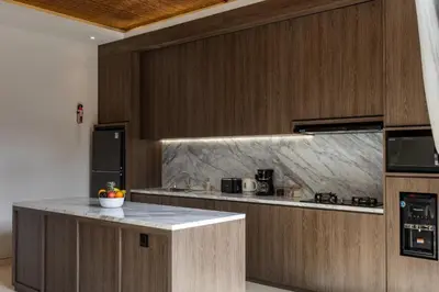 a kitchen with wooden cabinets and a counter top at Trendy Modern and Spacious 3Bd Villa in Umalas in Kerobokan