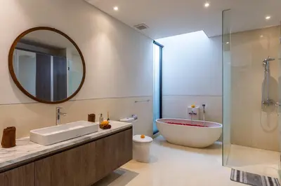 a bathroom with a tub and a large mirror at Luxury Chic 3bd Modern Villa in Umalas in Kerobokan