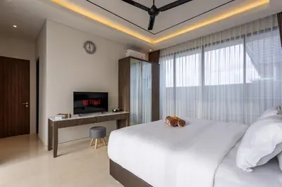 a bedroom with a large white bed and a tv at Luxury Chic 3bd Modern Villa in Umalas in Kerobokan