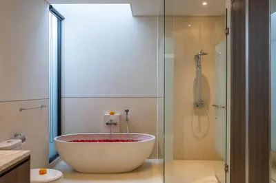 a bathroom with a large tub in a shower at Luxury Chic 3bd Modern Villa in Umalas in Kerobokan