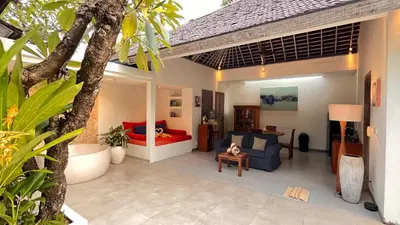 a patio with a couch and a bed in a house at The Decks Bali in Legian
