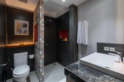 a bathroom with a white toilet and a sink at The New Moon Umalas in Seminyak