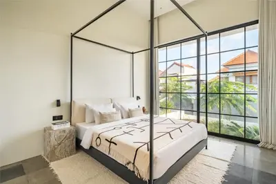 a bedroom with a bed and a large window at Casa Siella in Canggu