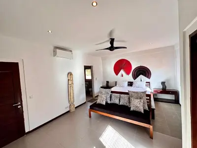 a bedroom with a bed with a red umbrella on the wall at The Getaway Villa Seminyak Bali in Seminyak