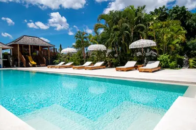 a pool at a resort with lounge chairs and umbrellas at Amazing Garden Room with Private Pool at Anwa Bali in Canggu