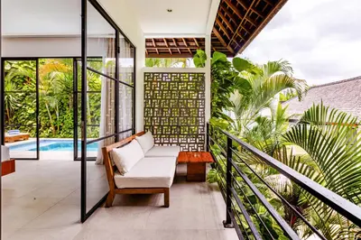a balcony with a chair and a pool at Amazing Garden Room with Private Pool at Anwa Bali in Canggu