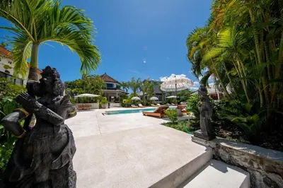 a garden with palm trees and a swimming pool at Amazing Garden Room with Private Pool at Anwa Bali in Canggu