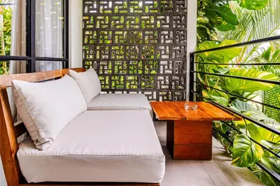 a chair and a table on a balcony with plants at Amazing Garden Room with Private Pool at Anwa Bali in Canggu