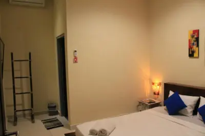 a bedroom with a bed with blue pillows at Chillin Kuta Homestay in Kuta