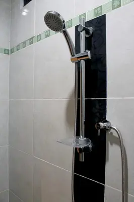a shower with a shower head in a bathroom at Chillin Kuta Homestay in Kuta