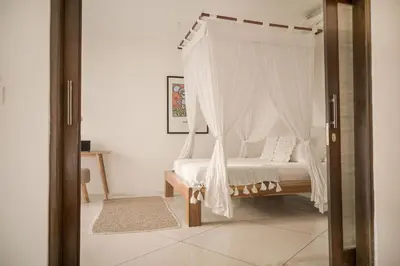 a bedroom with a bed with a canopy at Tropical 3bdr poolvilla in heart of Seminyak in Seminyak