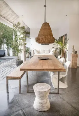 a dining room with a wooden table and chairs at Tropical 3bdr poolvilla in heart of Seminyak in Seminyak