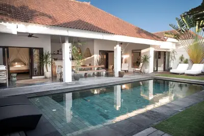 a swimming pool in front of a house at Tropical 3bdr poolvilla in heart of Seminyak in Seminyak