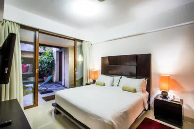 a bedroom with a large bed and a balcony at Kuta Reef Apartments in Kuta