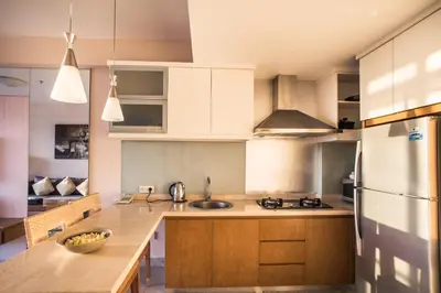 a kitchen with white cabinets and a counter top at Kuta Reef Apartments in Kuta